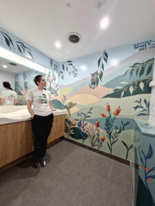 Artist Stacey Bennett looking at mural at Jimboomba Central parents room
