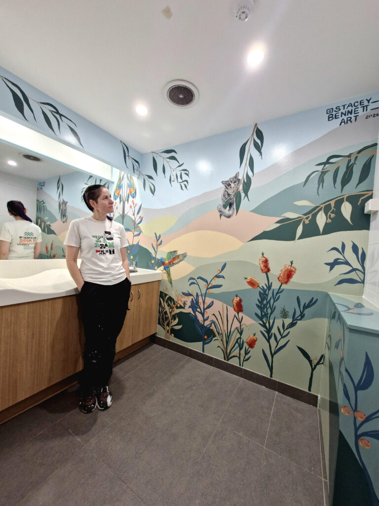 Artist Stacey Bennett looking at mural at Jimboomba Central parents room