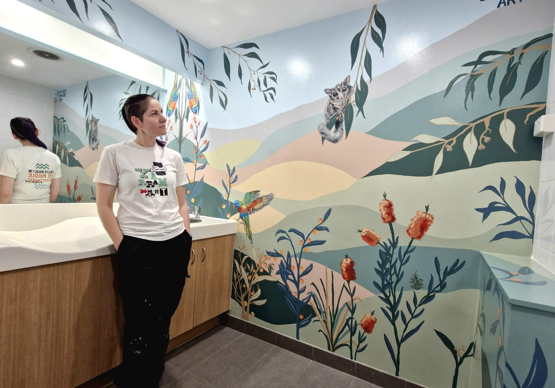 Artist Stacey Bennett looking at mural at Jimboomba Central parents room